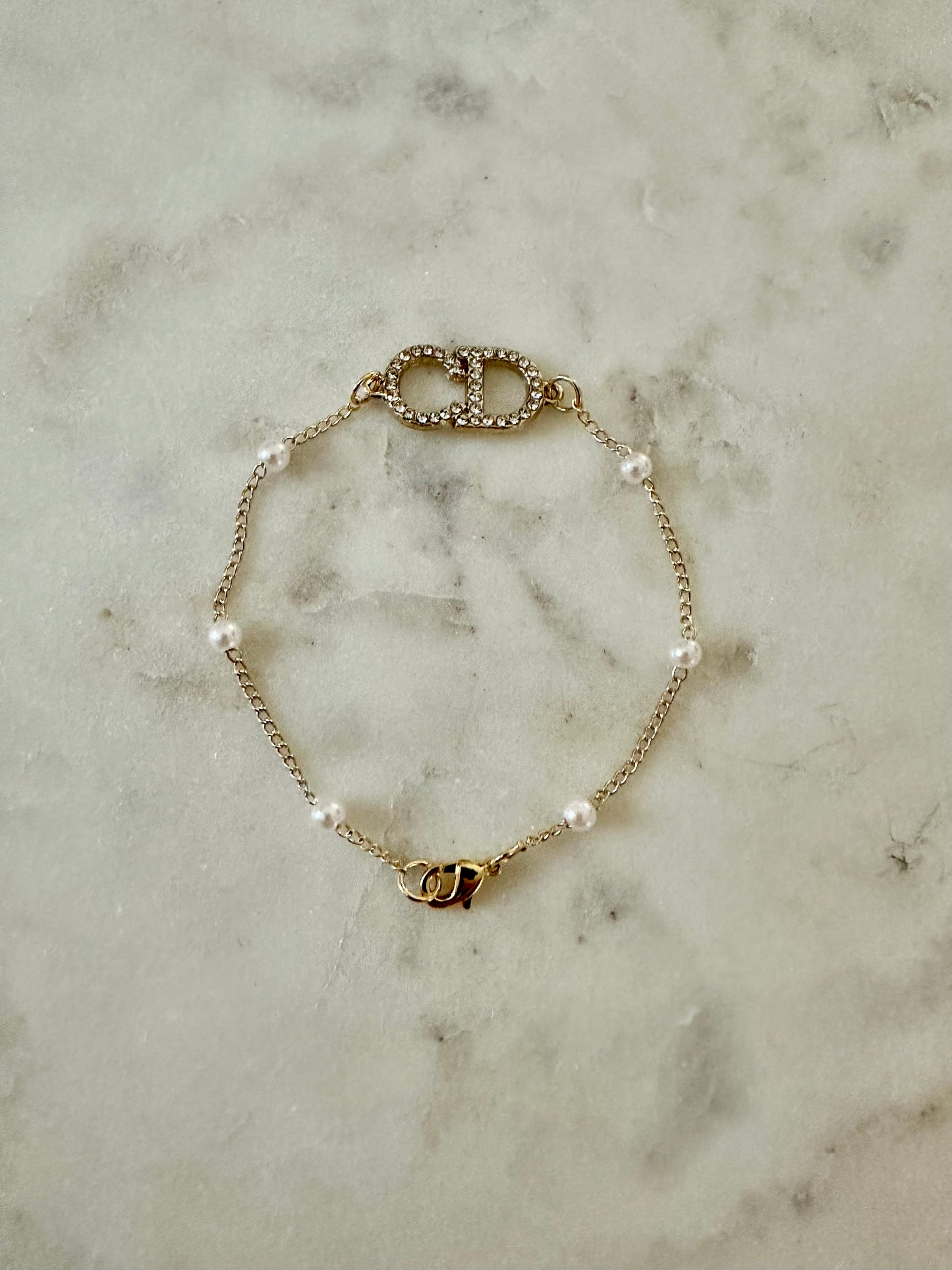 CD with faux pearl bracelet