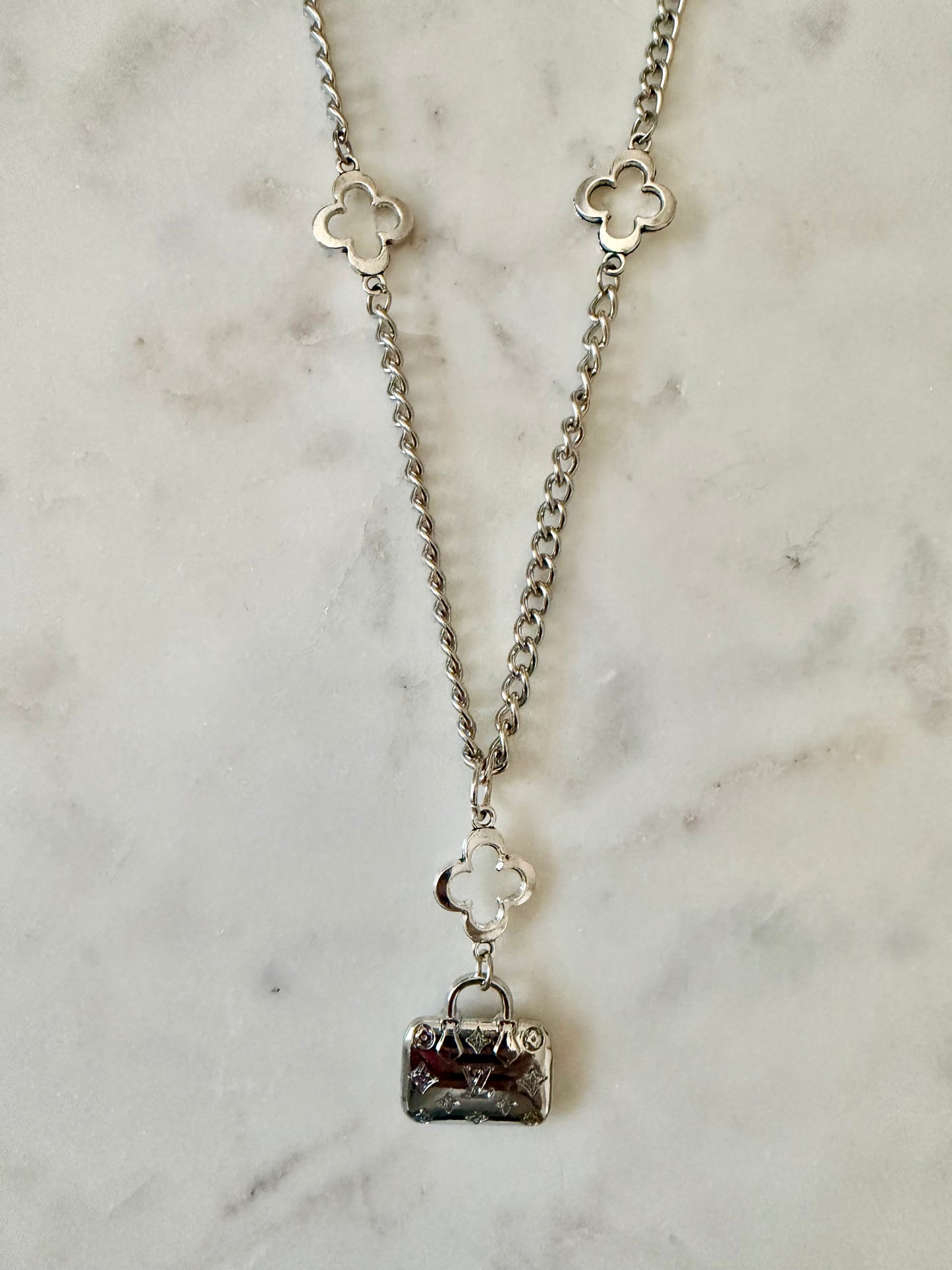 LV bag and clover necklace