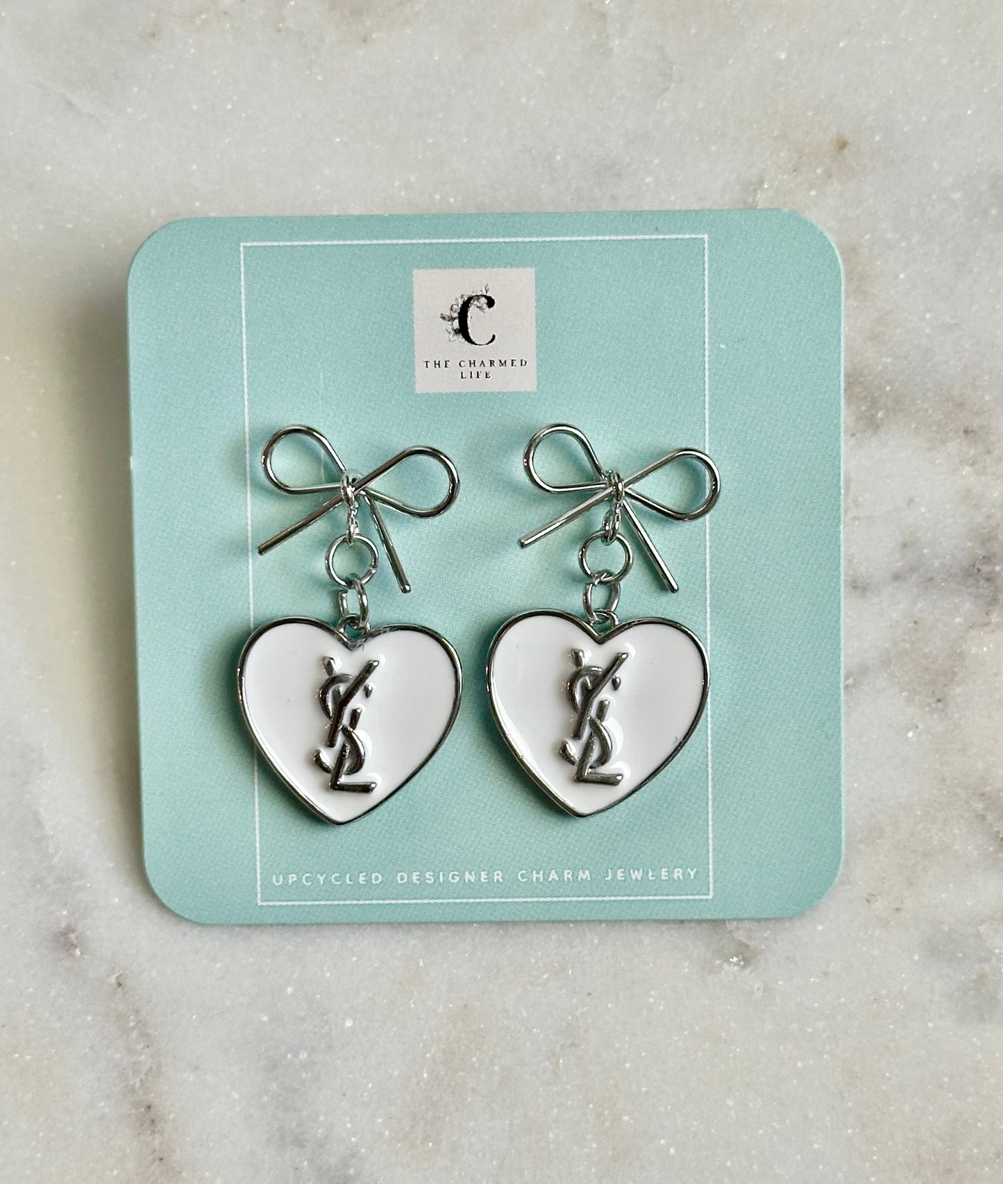 YSL white heart silver tone earrings