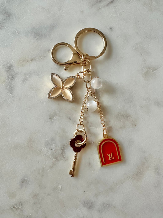 LV red and gold tone keychain