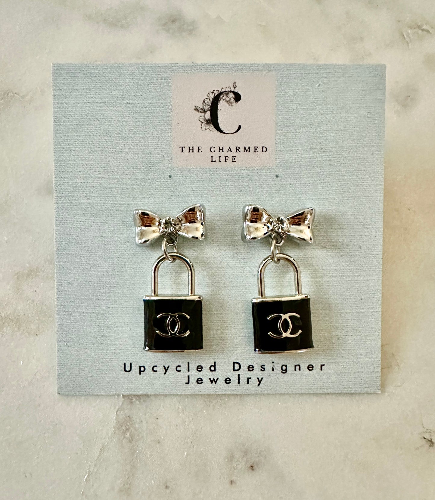 CC lock and bow silver tone earrings
