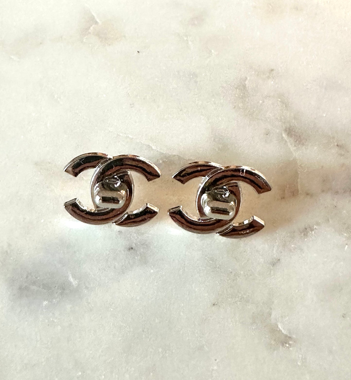 CC silver tone turn lock button earrings