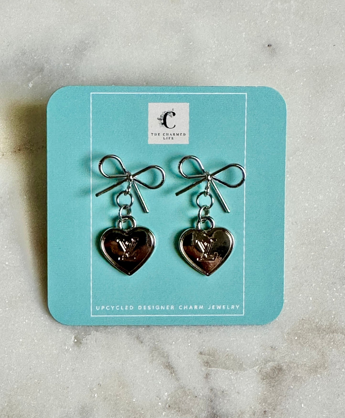 LV heart and bow silver tone earrings